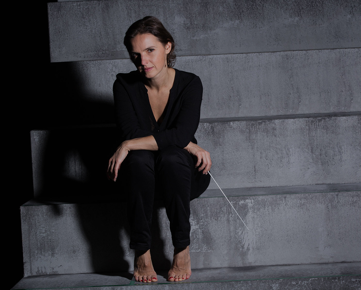 Oksana Lyniv sitting on concrete stairs